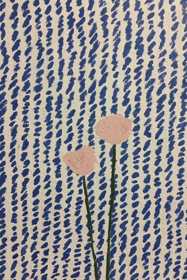 Two pastel flowers on a blue-and-white pattern