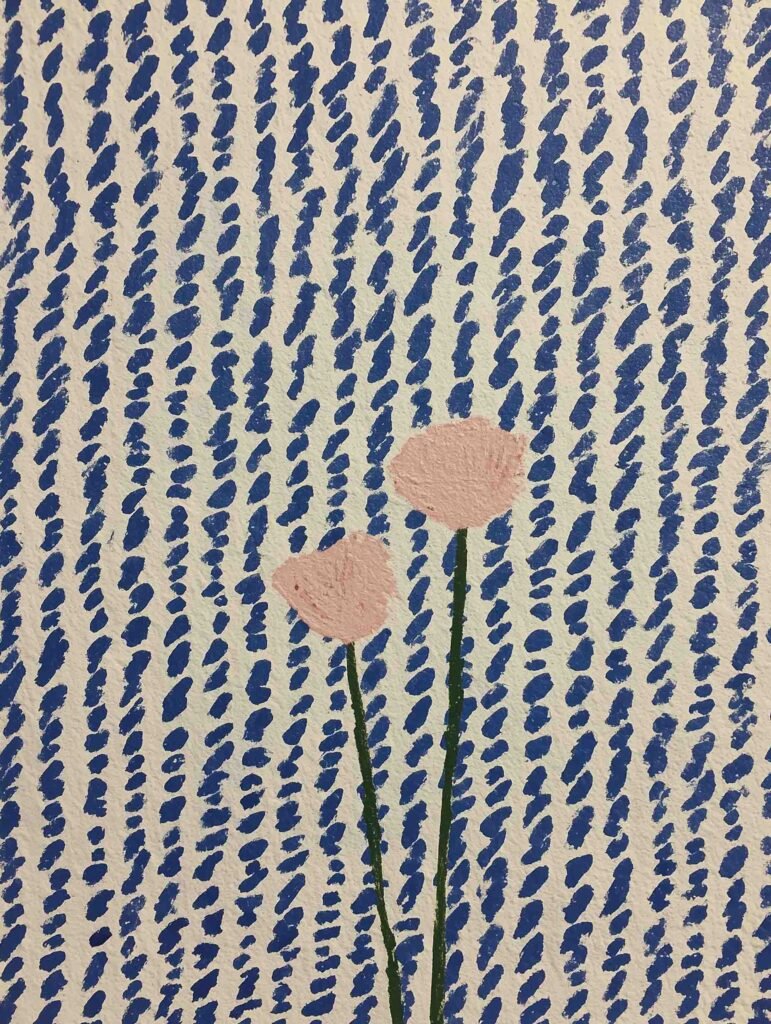 Two pastel flowers on a blue-and-white pattern