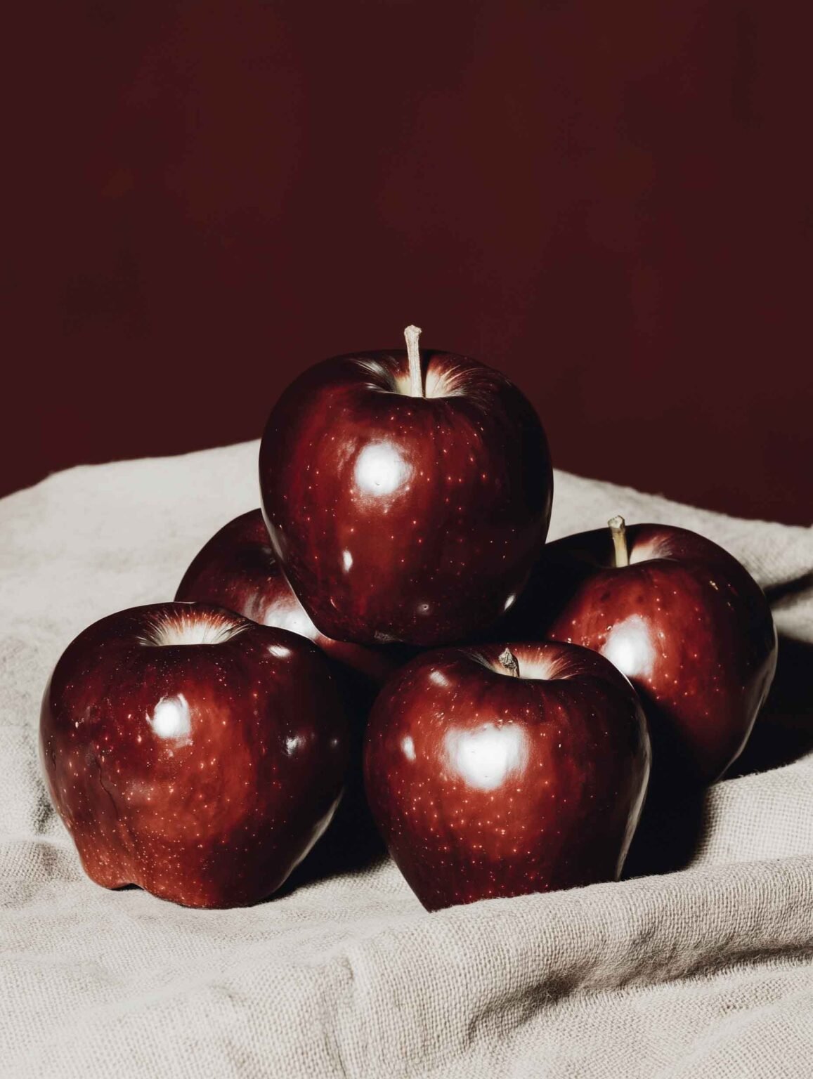 A bold art print of deep red apples with a moody, cinematic tone.